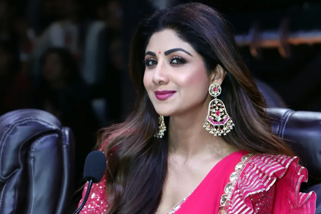 pink saree, long pink earnings, sarcastic smile, bindi, brown hairs, chairs